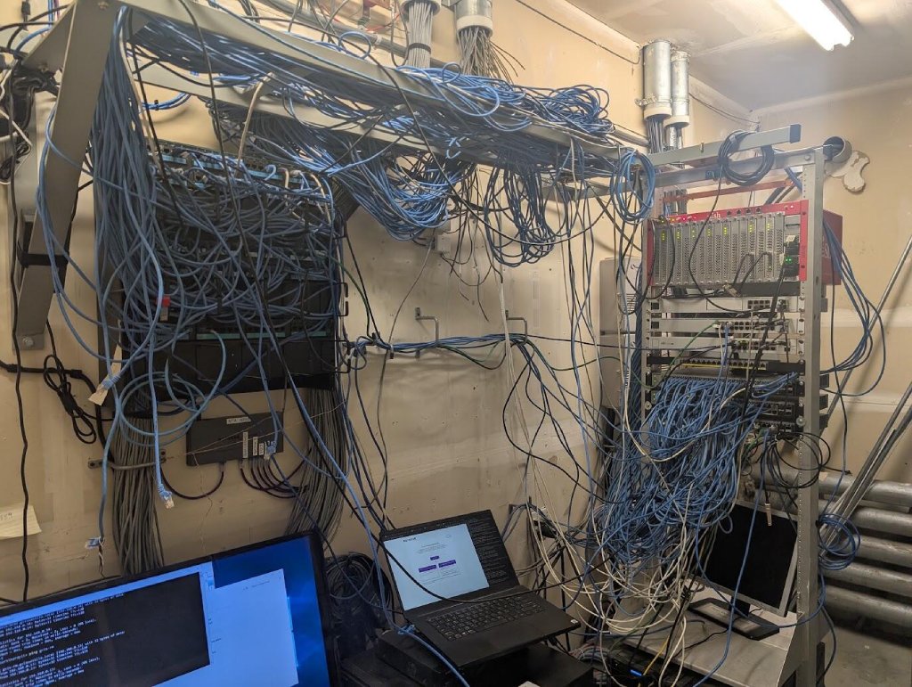 Communications room before cleanup with tangled and excessive network cabling